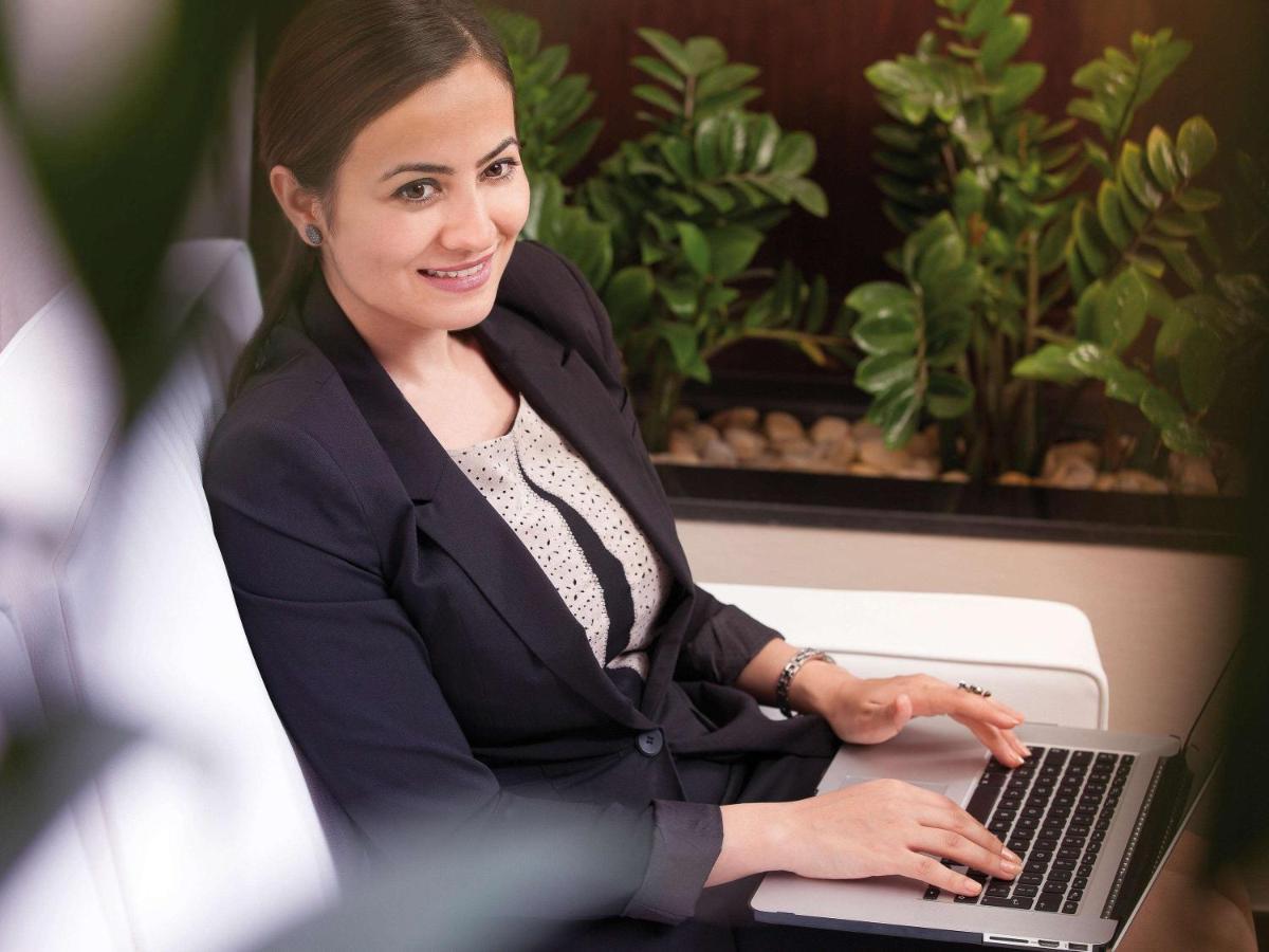 Movenpick Jumeirah Village Triangle 두바이 외부 사진 A business woman working on a laptop